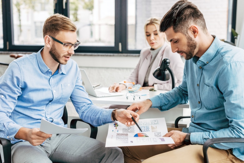 Three people sitting in an office, considering plans