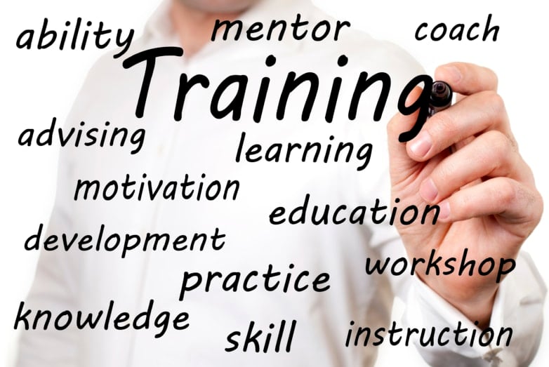 A man writing the word "training" on the screen, along with other smaller words