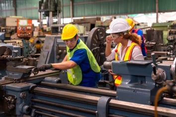 Technicians and engineers are working on industrial machines in a factory
